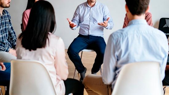 Группа слушает мужчину на терапии в кругу